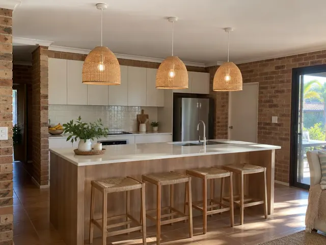 Three woven pendant lights above a kitchen island in a brick and timber home in Palm Beach