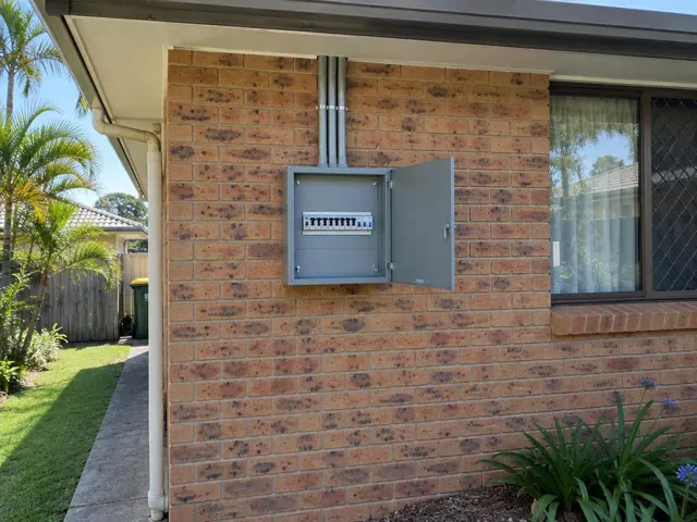 Exterior switchboard on a brick house wall beside a window in Elanora